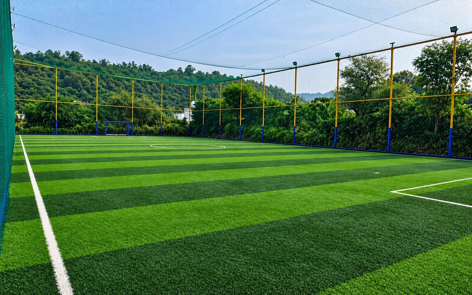 Footballer on a floodlit turf pitch